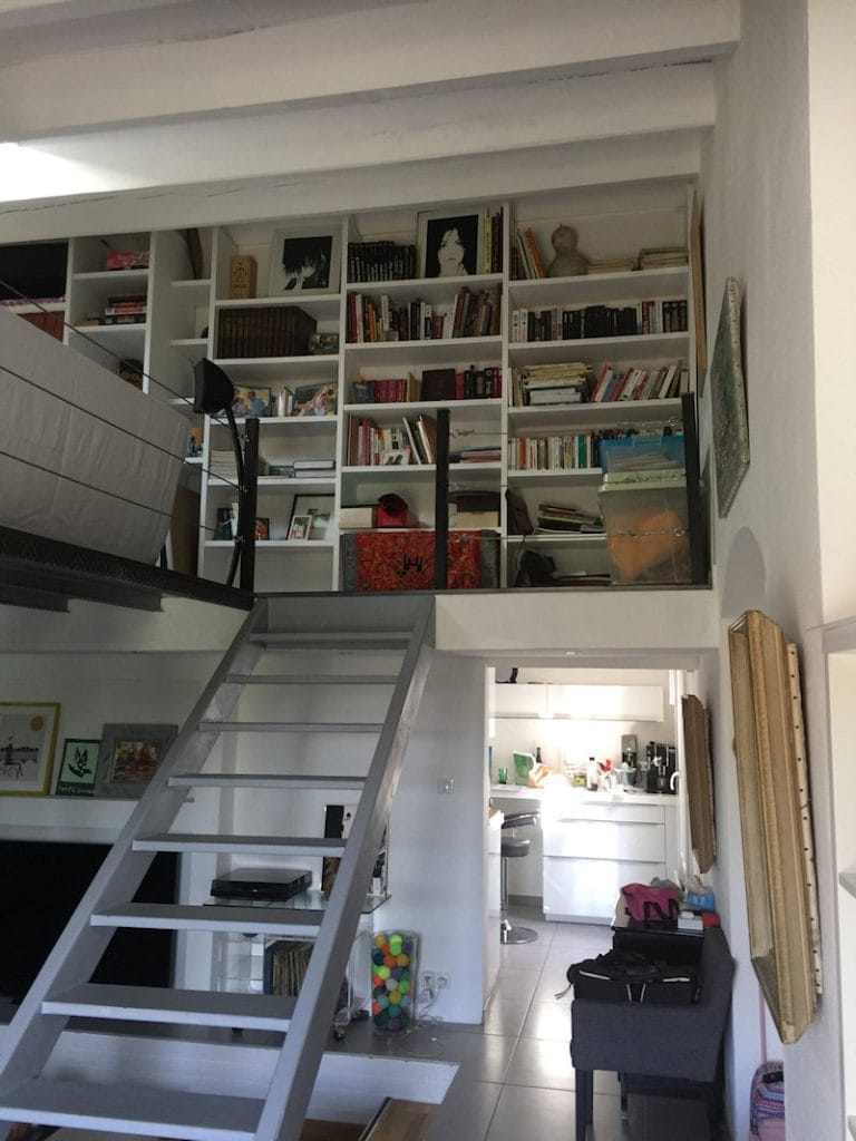 Bibliothèque mezzanine sur mesure et fonctionnelle dans un intérieur à Toulouse, optimisant l'espace avec des étagères du sol au plafond.